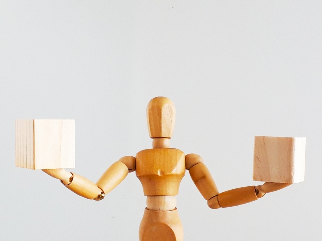 木のブロックを両手に持つ人形