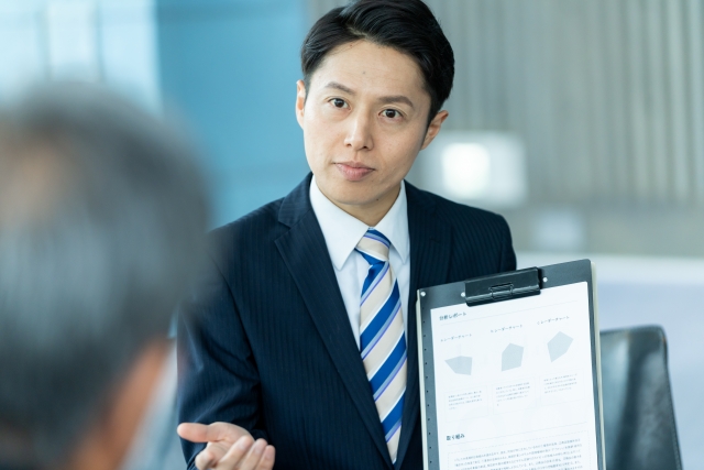 説明するスーツの男性