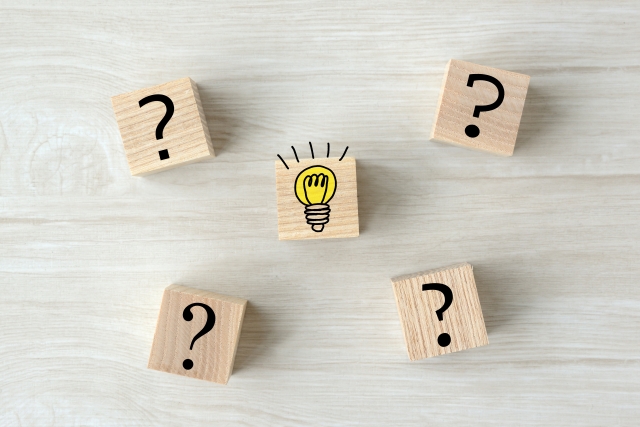 はてなマークと電球マークの書かれた木のブロック